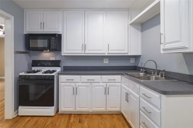 a kitchen with white cabinets and stainless steel appliances