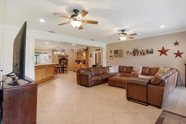 a living room with furniture kitchen view and a chandelier
