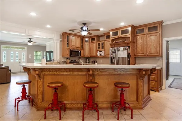 a kitchen with stainless steel appliances granite countertop table chairs sink and cabinets