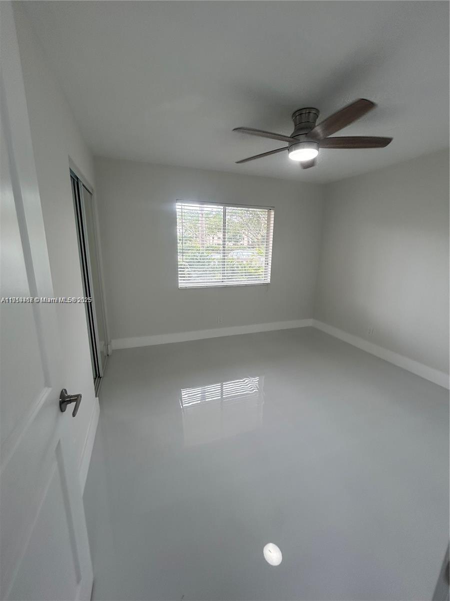 6935 Huntington Lane, Unit 107 Delray Beach, FL 33446 - Photo 11 of 23 wooden floor in an empty room with a window