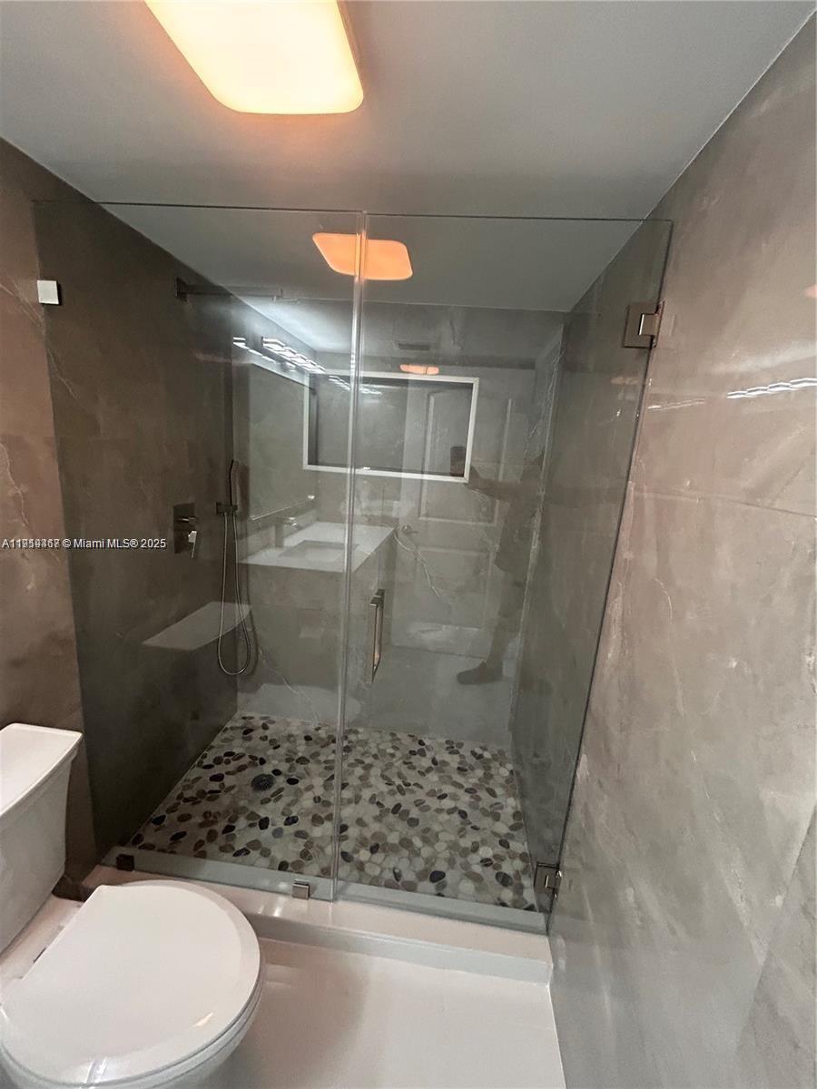 6935 Huntington Lane, Unit 107 Delray Beach, FL 33446 - Photo 14 of 23 a bathroom with a toilet and shower