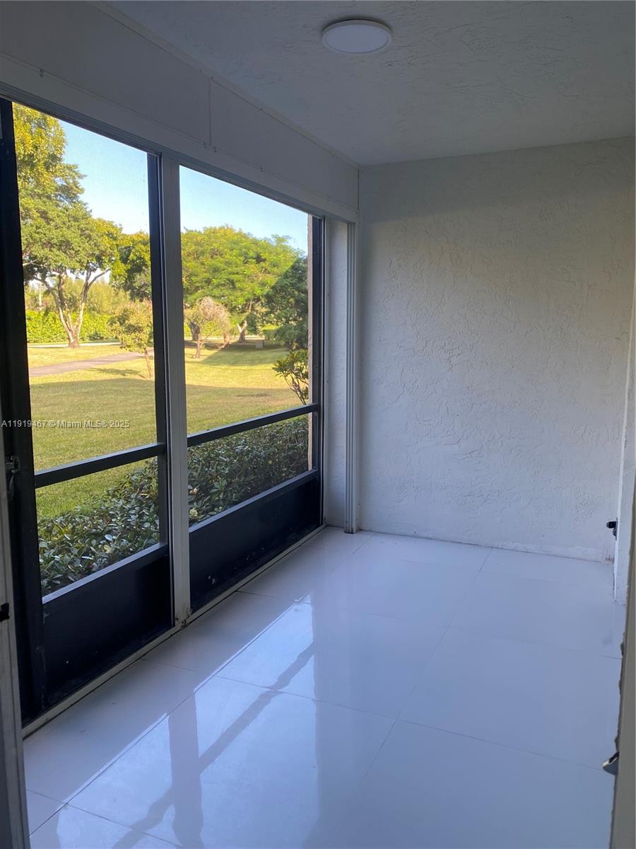 6935 Huntington Lane, Unit 107 Delray Beach, FL 33446 - Photo 23 of 23 wooden floor in an empty room with a large window