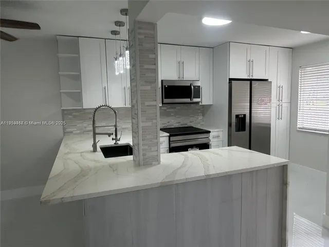 a kitchen with stainless steel appliances a refrigerator sink and microwave