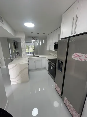 a large kitchen with lot of cabinets and stainless steel appliances