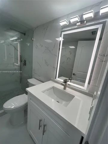 a bathroom with a double vanity sink toilet and shower