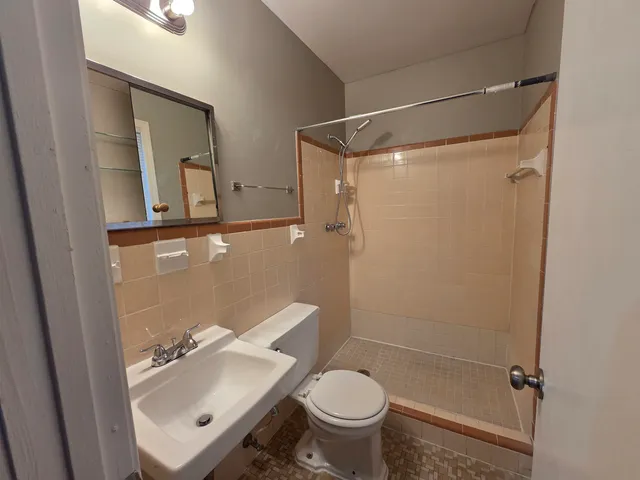 a bathroom with a toilet and a shower