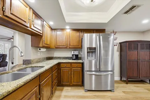 a kitchen with stainless steel appliances granite countertop a refrigerator sink and cabinets