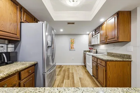 a kitchen with stainless steel appliances granite countertop a refrigerator a stove and a sink