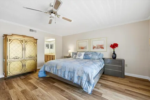 a spacious bedroom with a bed a dresser and potted plants