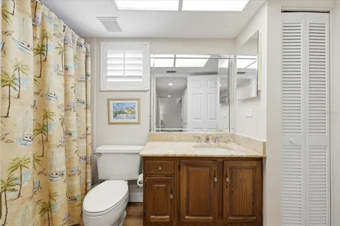a bathroom with a granite countertop sink toilet mirror and bathtub