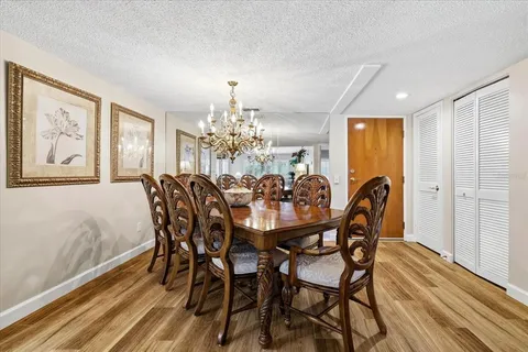 a view of a dining room with furniture a chandelier and wooden floor