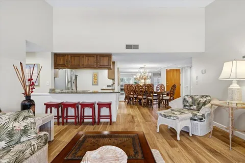 a living room with dining room and wooden floor