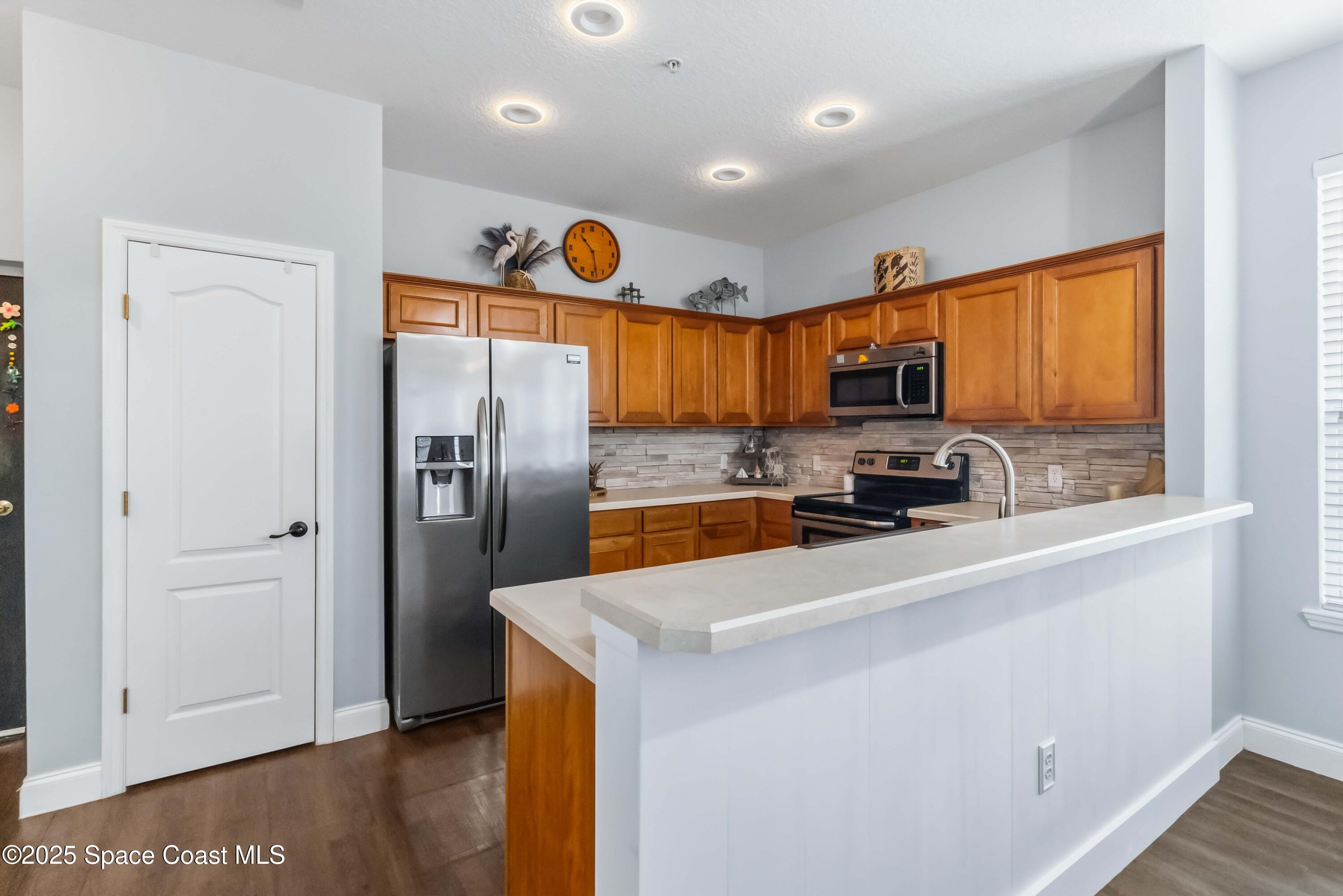 3607 Clay Brick Road Harmony, FL 34773 - Photo 15 of 72 a kitchen with stainless steel appliances a refrigerator a sink a stove a microwave oven cabinets and wooden floor