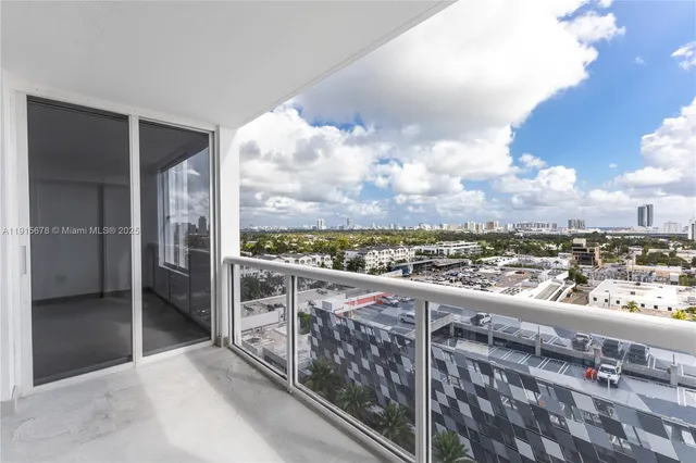 a view of a big room with wooden floor and windows