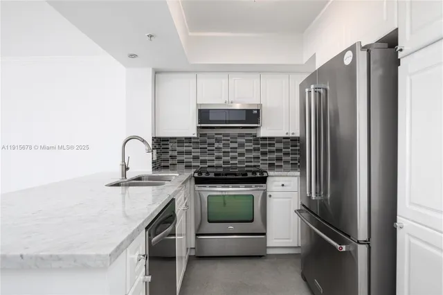 a kitchen with white cabinets stainless steel appliances and sink