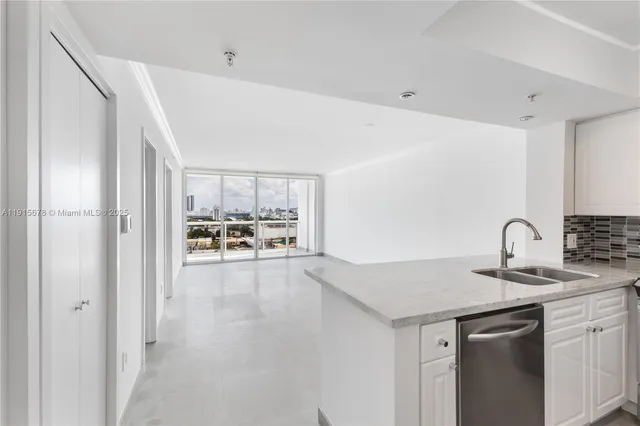 an empty room with floor to ceiling window and an outdoor view