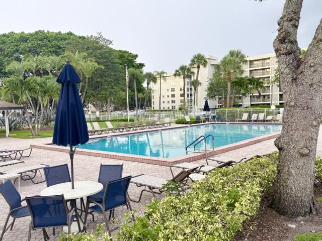 2671 South Course Drive, Unit 108 Pompano Beach, FL 33069 - Photo 23 of 40 a view of a chairs and table in patio with a swimming pool