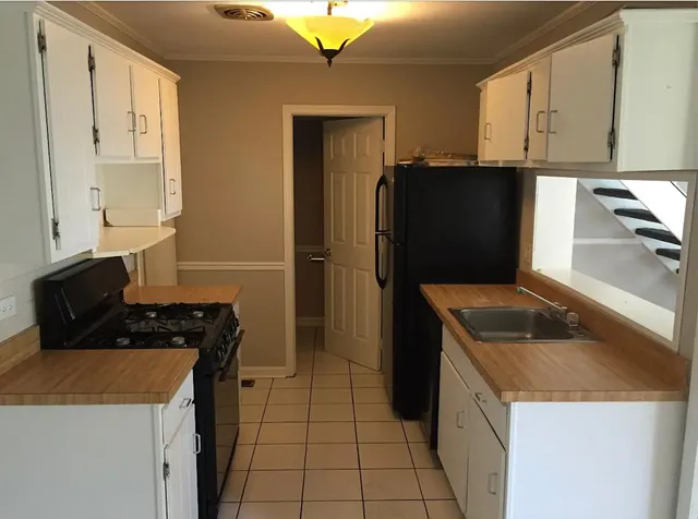 a kitchen with granite countertop a refrigerator and a sink