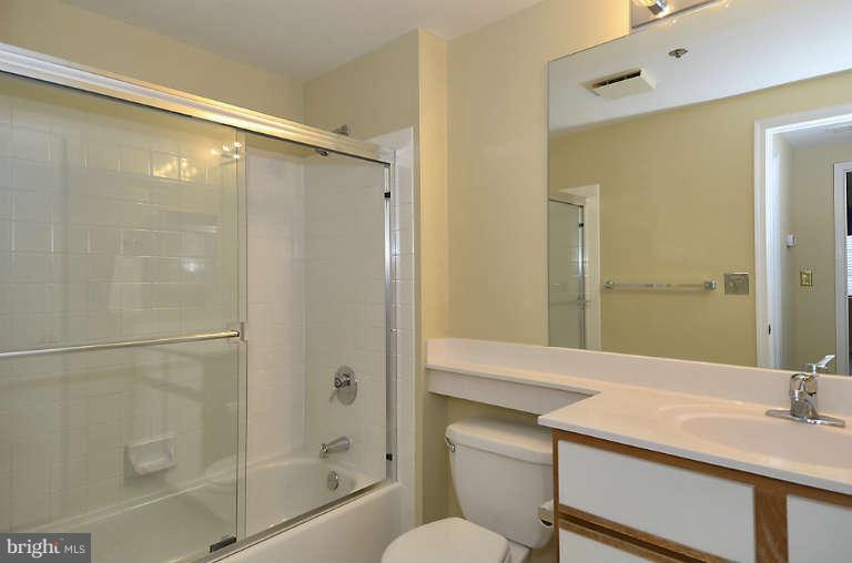 24 Courthouse Square, Unit 907 Rockville, MD 20850 - Photo 15 of 30 a bathroom with a granite countertop shower sink vanity and toilet