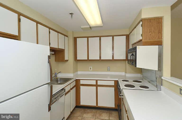24 Courthouse Square, Unit 907 Rockville, MD 20850 - Photo 4 of 30 a kitchen with a sink a stove and a refrigerator