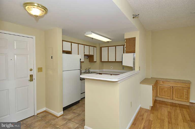 24 Courthouse Square, Unit 907 Rockville, MD 20850 - Photo 5 of 30 a kitchen with a sink and a refrigerator