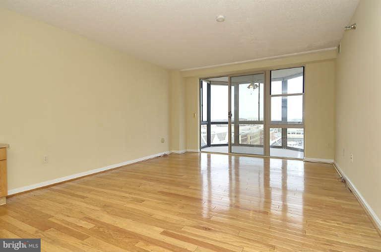 24 Courthouse Square, Unit 907 Rockville, MD 20850 - Photo 7 of 30 a view of an empty room with wooden floor and a window