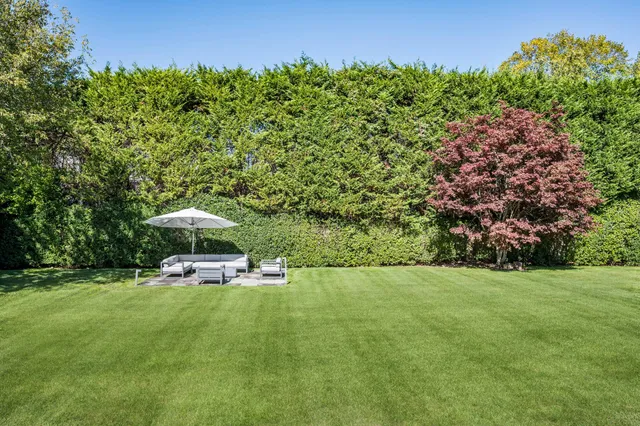a view of a swimming pool and lounge chairs in the garden