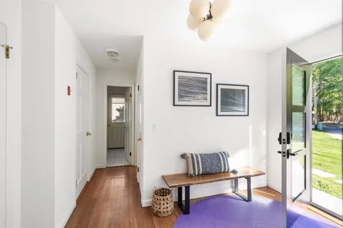 a view of a hallway with wooden floor and windows