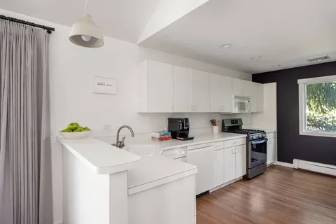 a kitchen with a sink a stove cabinets and a refrigerator