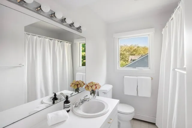 a bathroom with a sink a toilet and a mirror