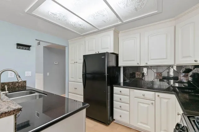 a kitchen with granite countertop a sink stainless steel appliances and cabinets