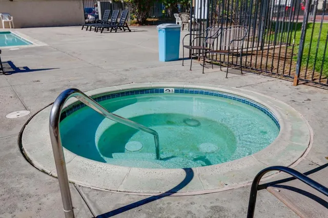 a view of a swimming pool with a patio and fire pit