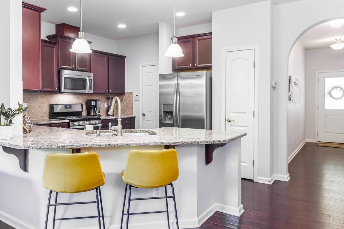 68 Argonaut Drive Durham, NC 27705 - Photo 9 of 29 a kitchen with stainless steel appliances granite countertop a sink a stove a refrigerator and cabinets