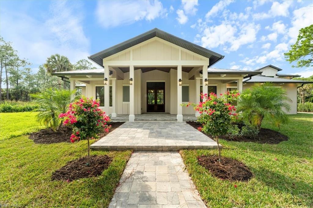 699 1st Street Northwest Naples, FL 34120 - Photo 1 of 42 a front view of a house with garden