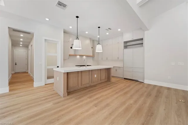 a large white kitchen with a refrigerator a sink and a stove