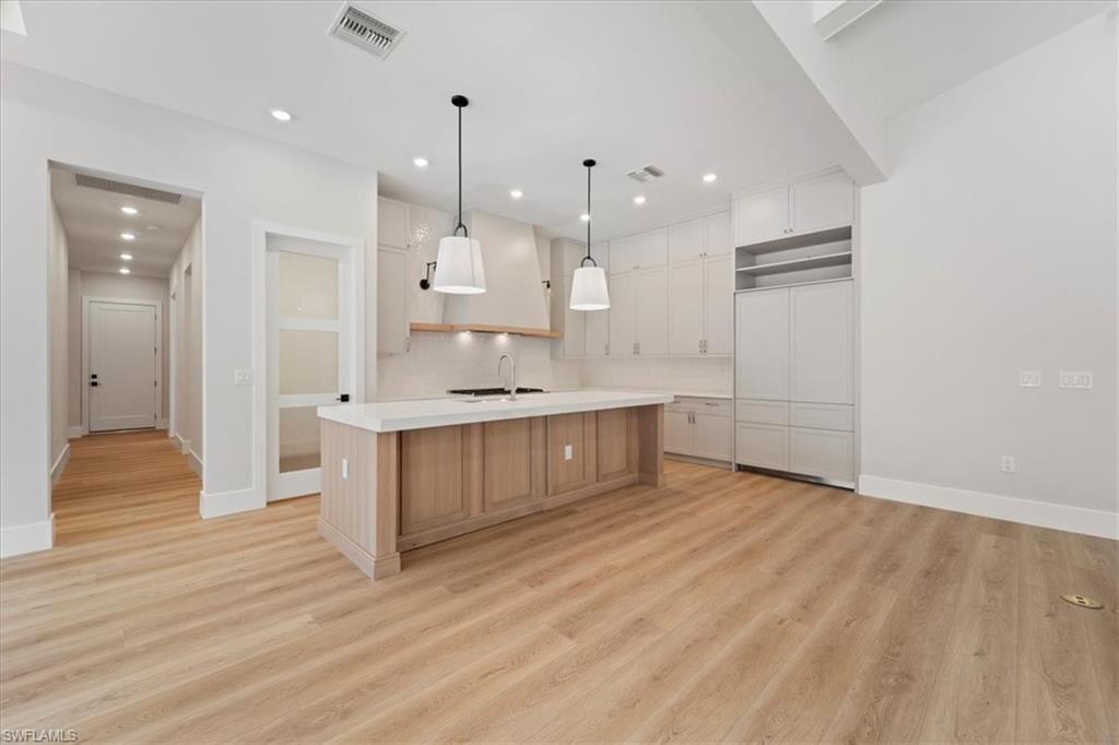 699 1st Street Northwest Naples, FL 34120 - Photo 12 of 42 a large white kitchen with a refrigerator a sink and a stove