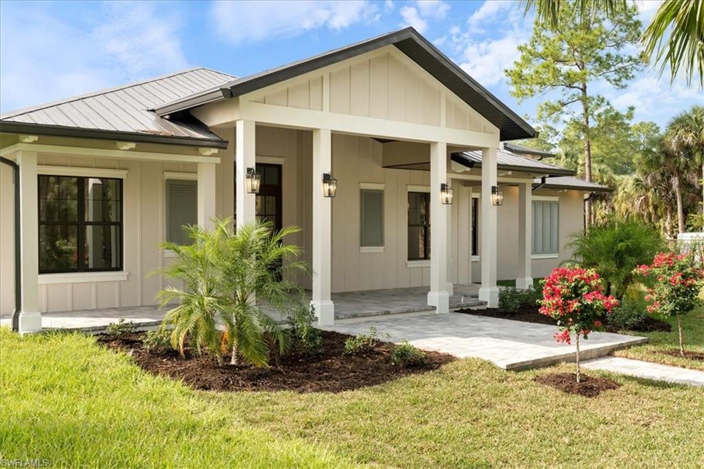 699 1st Street Northwest Naples, FL 34120 - Photo 2 of 42 a front view of a house with a yard