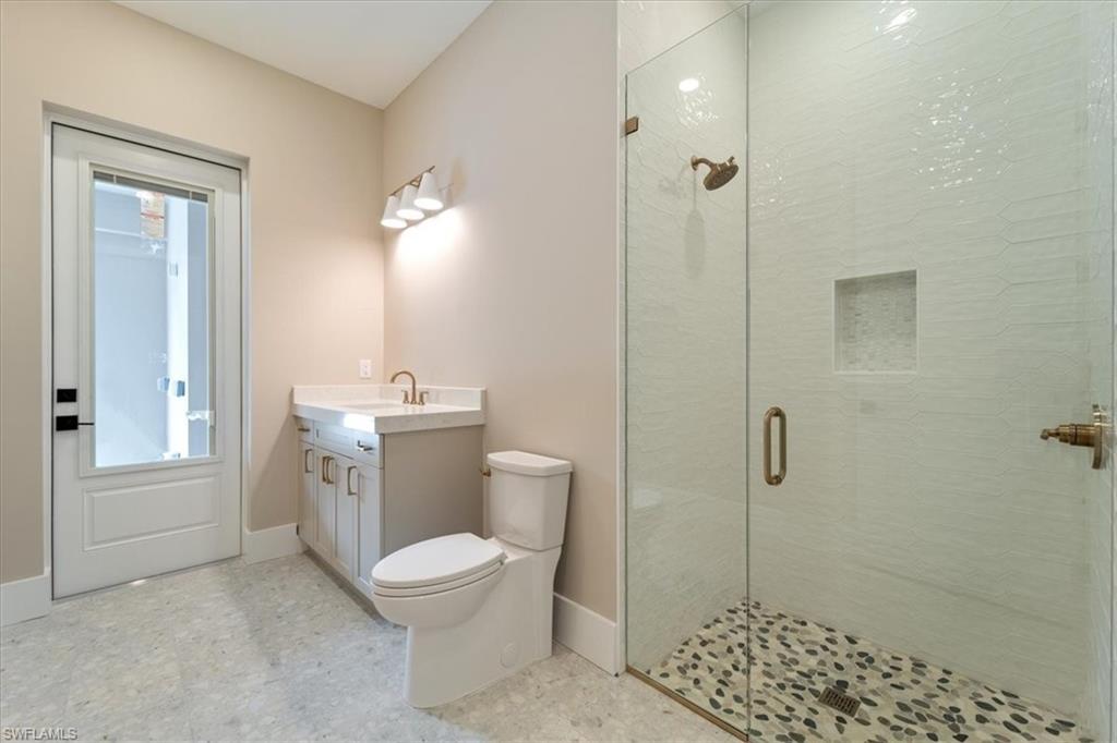 699 1st Street Northwest Naples, FL 34120 - Photo 25 of 42 a bathroom with a toilet a sink a mirror a shower and vanity