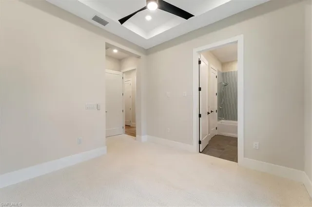 an empty room with fan and entrance