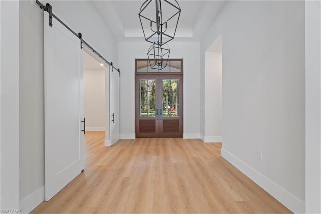 699 1st Street Northwest Naples, FL 34120 - Photo 5 of 42 a view of an empty room with wooden floor and a window