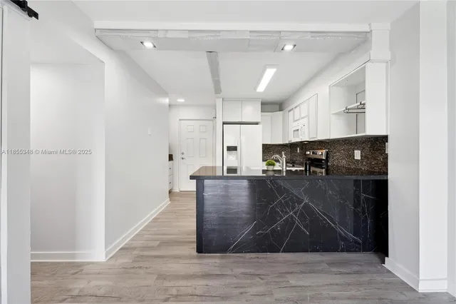 a kitchen with a stove and white cabinets