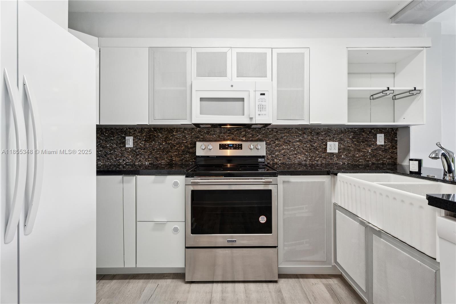 750 Northeast 64th Street, Unit B500 Miami, FL 33138 - Photo 15 of 29 a kitchen with a stove and white cabinets