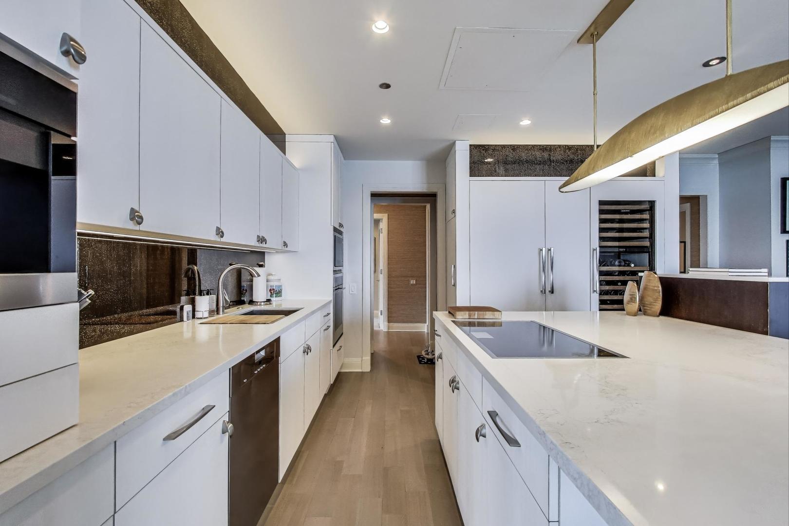 840 North Lake Shore Drive, Unit 2401 Chicago, IL 60611 - Photo 18 of 40 a large kitchen with stainless steel appliances granite countertop a sink and a refrigerator