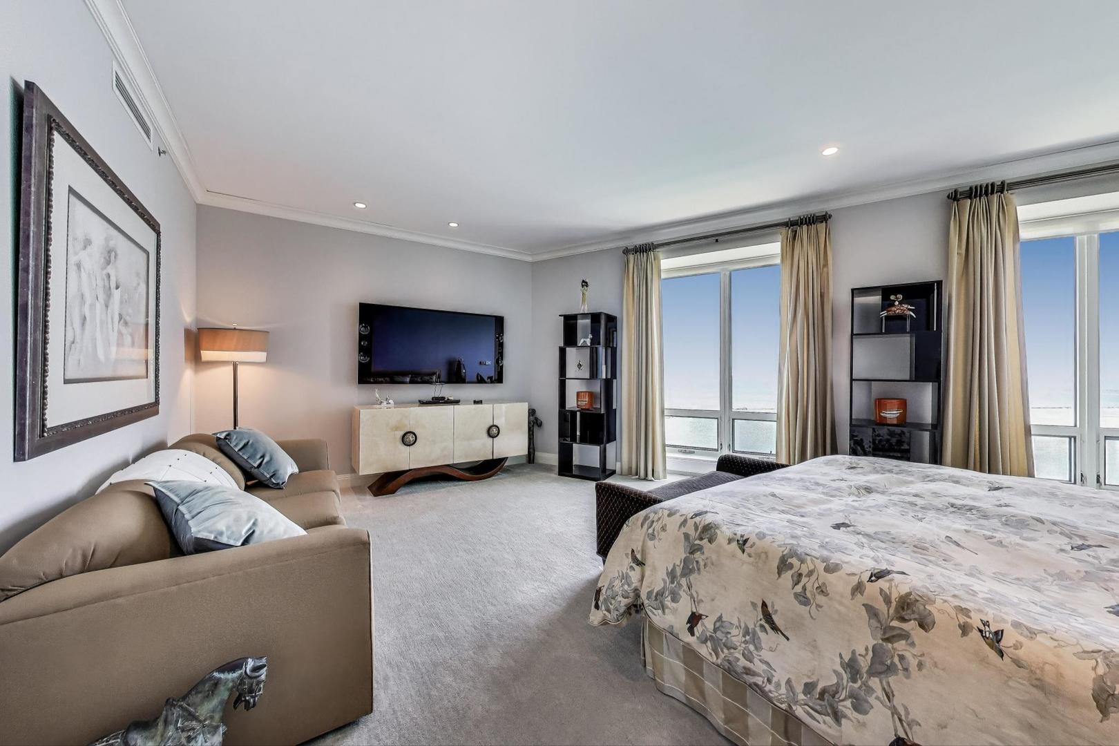 840 North Lake Shore Drive, Unit 2401 Chicago, IL 60611 - Photo 28 of 40 a spacious bedroom with a bed and a flat screen tv