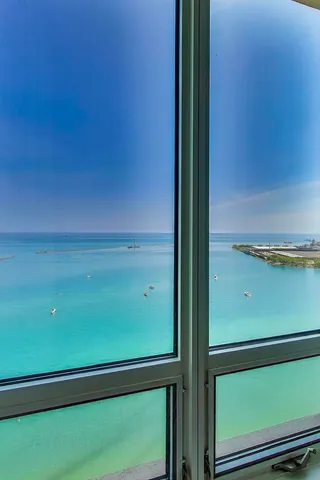 a large white kitchen with a sink and stainless steel appliances
