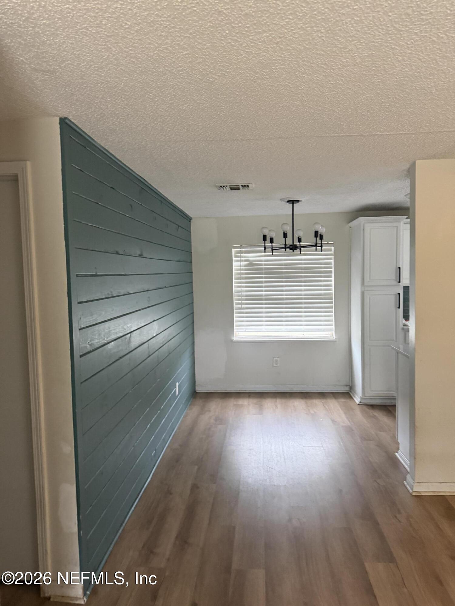 7539 Walden Road Jacksonville, FL 32244 - Photo 3 of 18 a view of kitchen and empty room with wooden floor