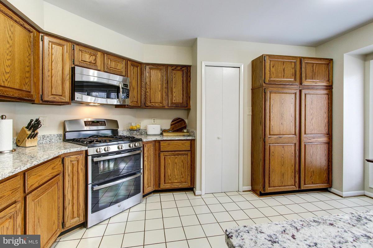 11614 Chapel Cross Way Reston, VA 20194 - Photo 10 of 30 a kitchen with stainless steel appliances granite countertop a stove a sink and a refrigerator