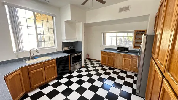 a kitchen with a sink a stove a refrigerator and a window