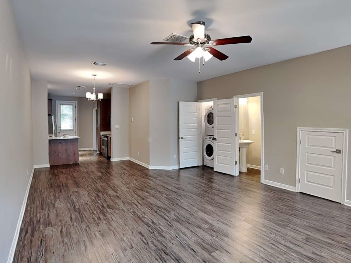179 Holly Street, Unit 503 Georgetown, TX 78626 - Photo 3 of 18 a view of an empty room with wooden floor and a ceiling fan