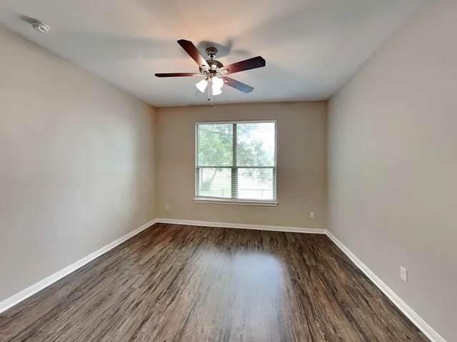 wooden floor in an empty room with a window